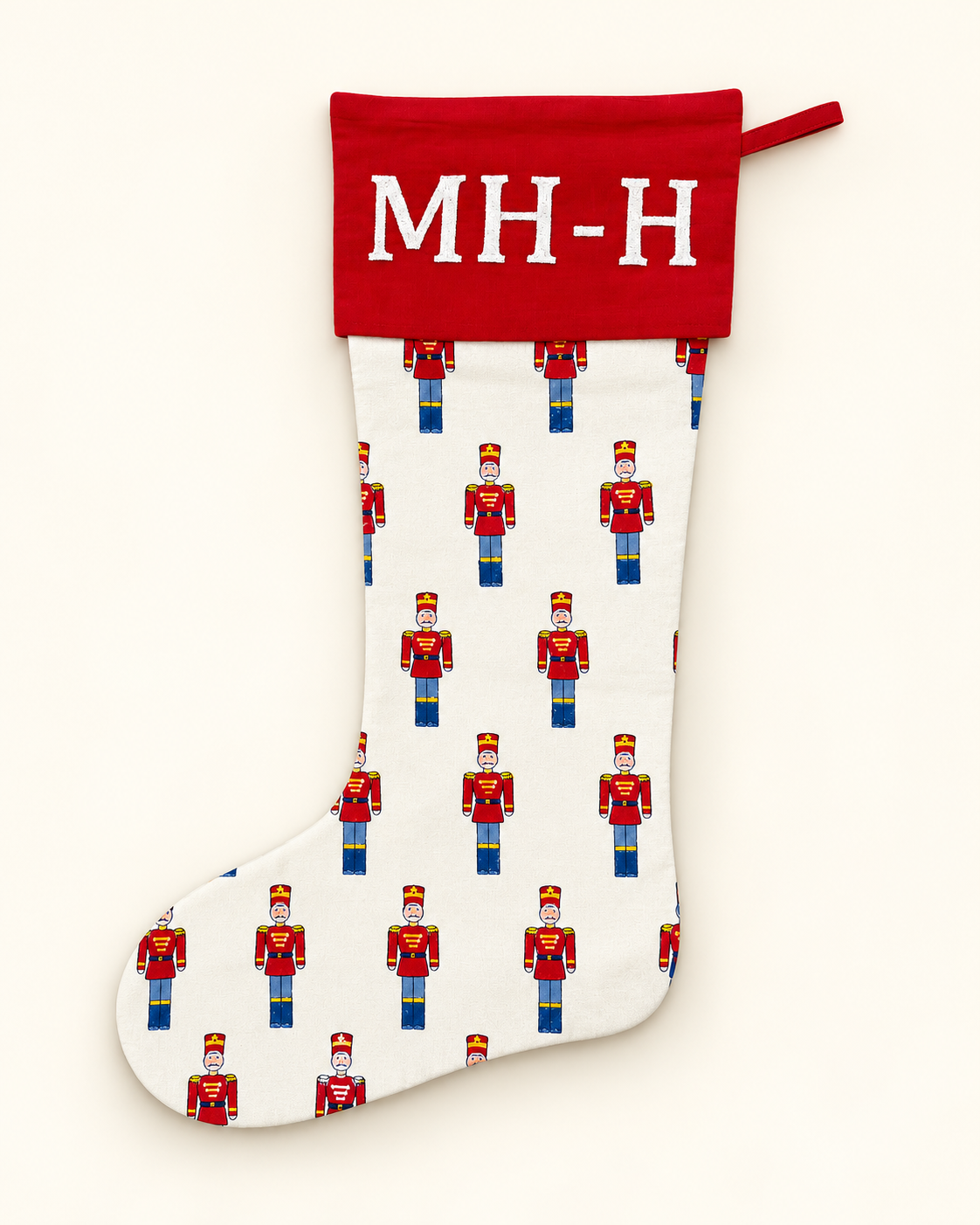 Personalised red toy soldier Christmas stocking with red cuff and white embroidered initials.
