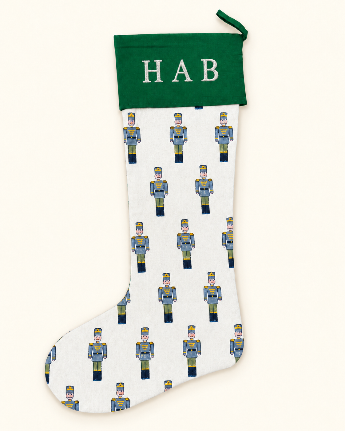 Personalised green toy soldier Christmas stocking with blue soldiers, forest green cuff and white embroidered HAB initials.