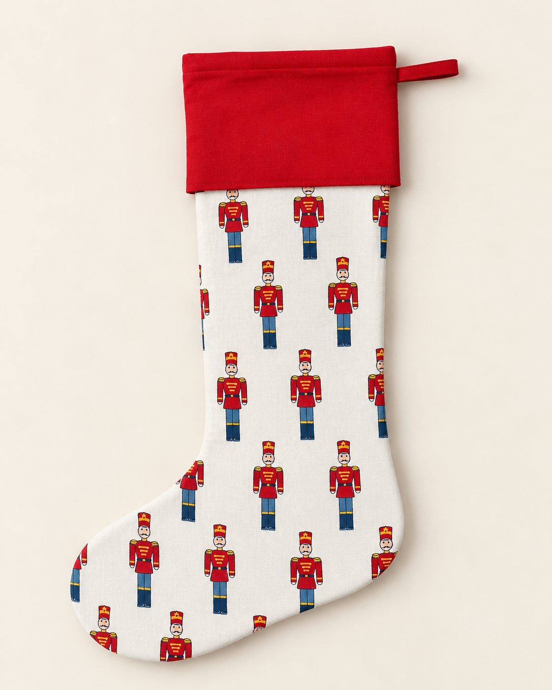 Red Toy Soldier Christmas Stocking by Kapara London, featuring hand block printed cotton, traditional toy soldiers and a red cuff.
