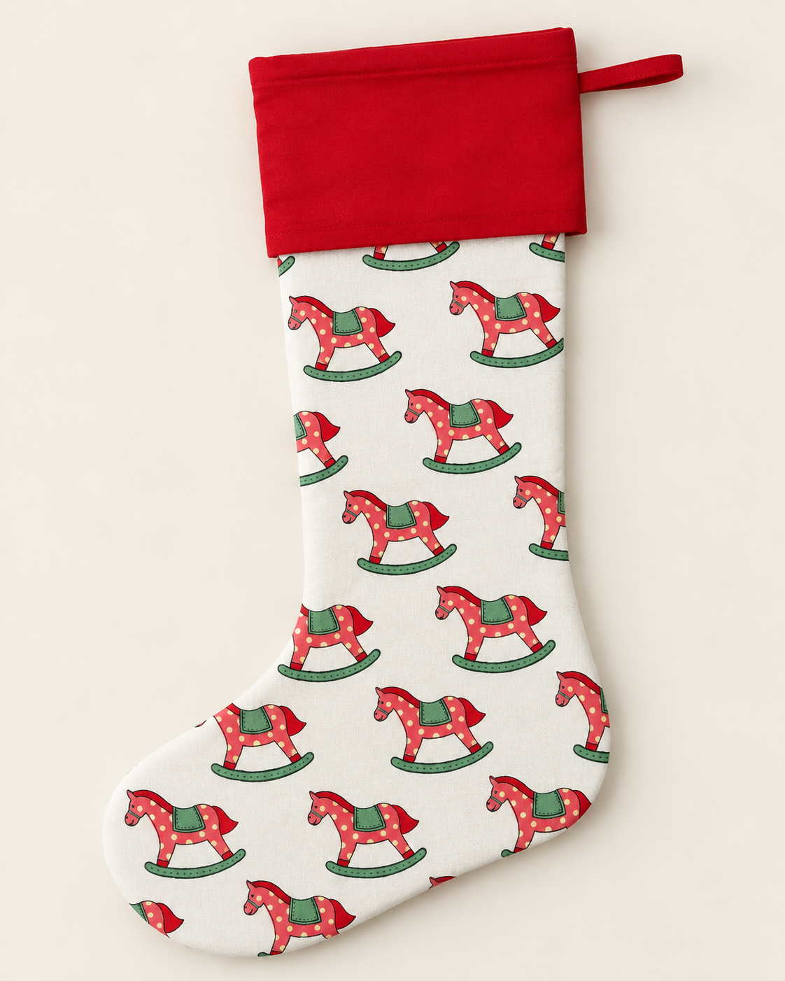 Pink, red and green rocking horse Christmas stocking with a red cotton cuff, hand block printed by Kapara London.