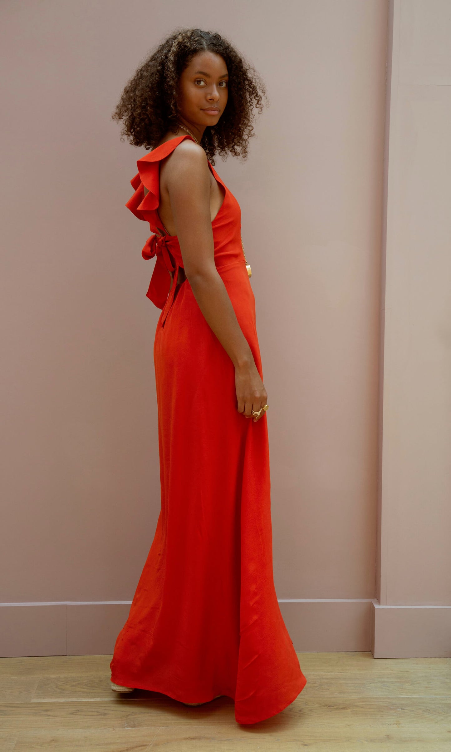 Bright red bespoke bridesmaid dress against blush background